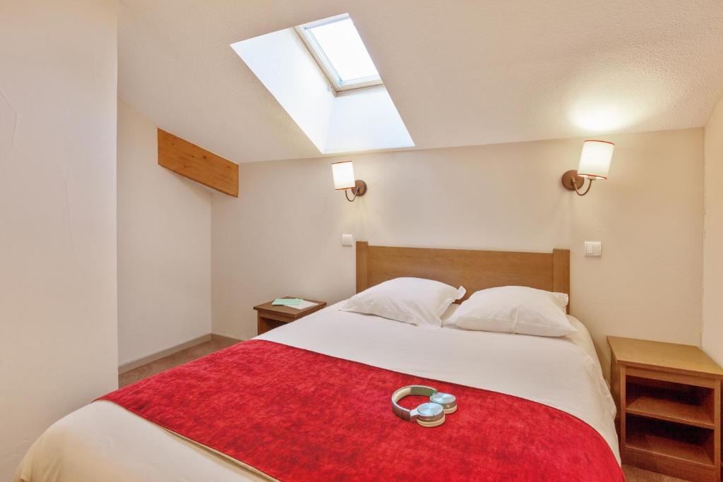 une chambre avec un grand lit avec une couverture rouge dans l'établissement Résidence Pierre & Vacances l'Albane, à Vars