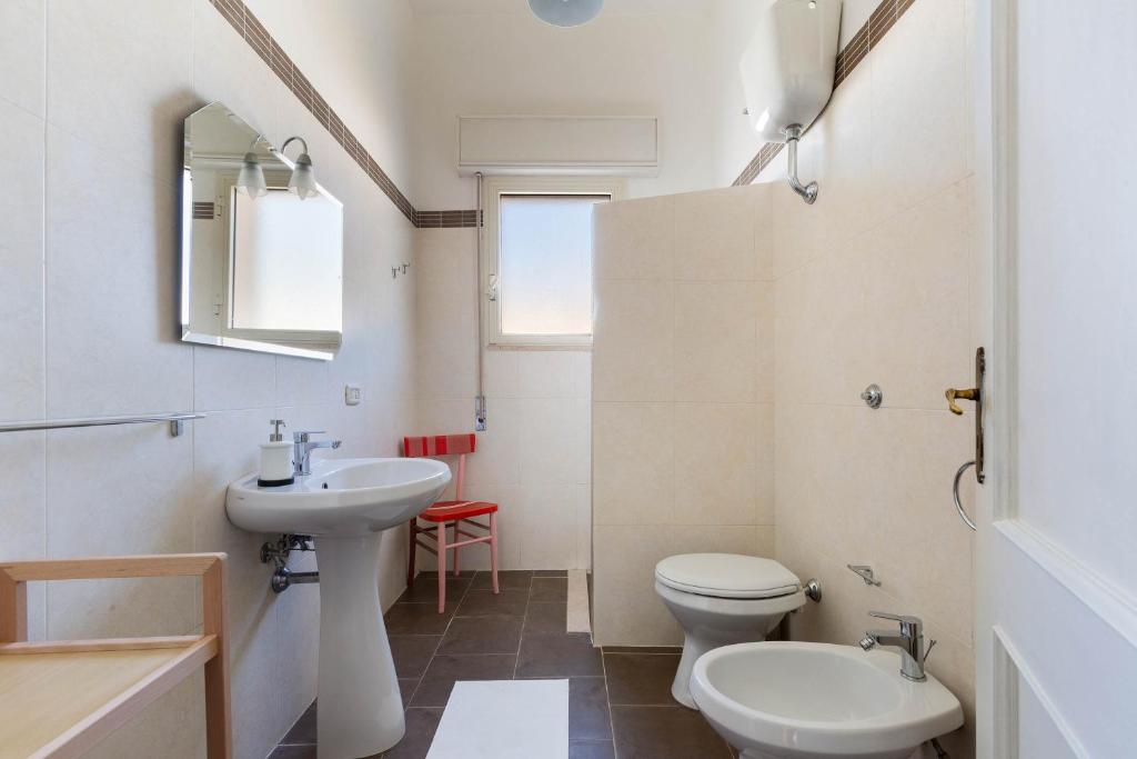 une salle de bain blanche avec un lavabo et des toilettes dans l'établissement Villa Graziana by BarbarHouse, à Mandurie