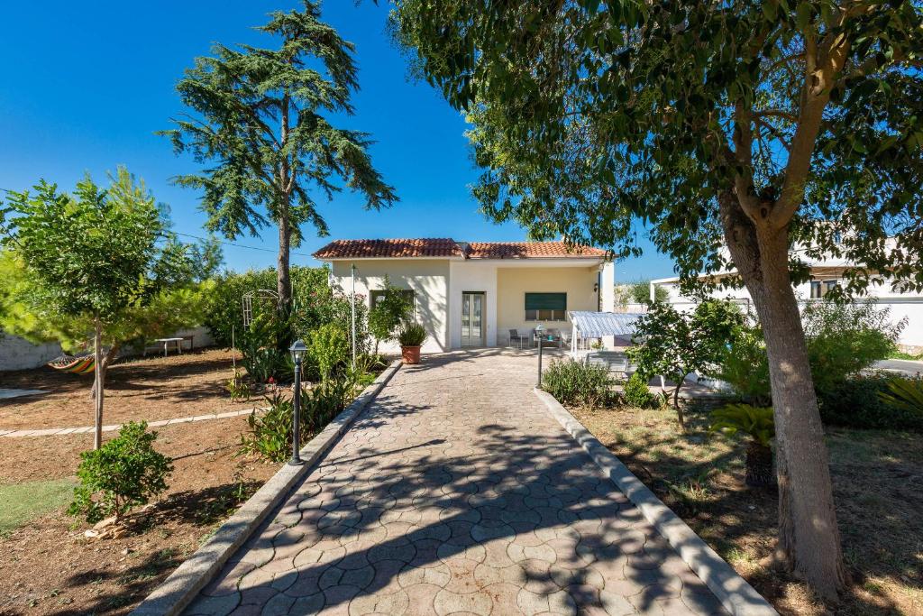 une passerelle menant à une maison blanche avec un arbre dans l'établissement Villa Graziana by BarbarHouse, à Mandurie