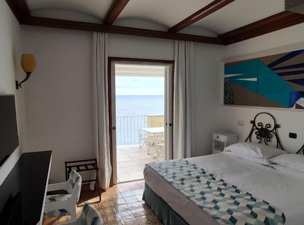 une chambre avec un lit et une vue sur l'océan dans l'établissement Taverna Del Capitano, à Massa Lubrense