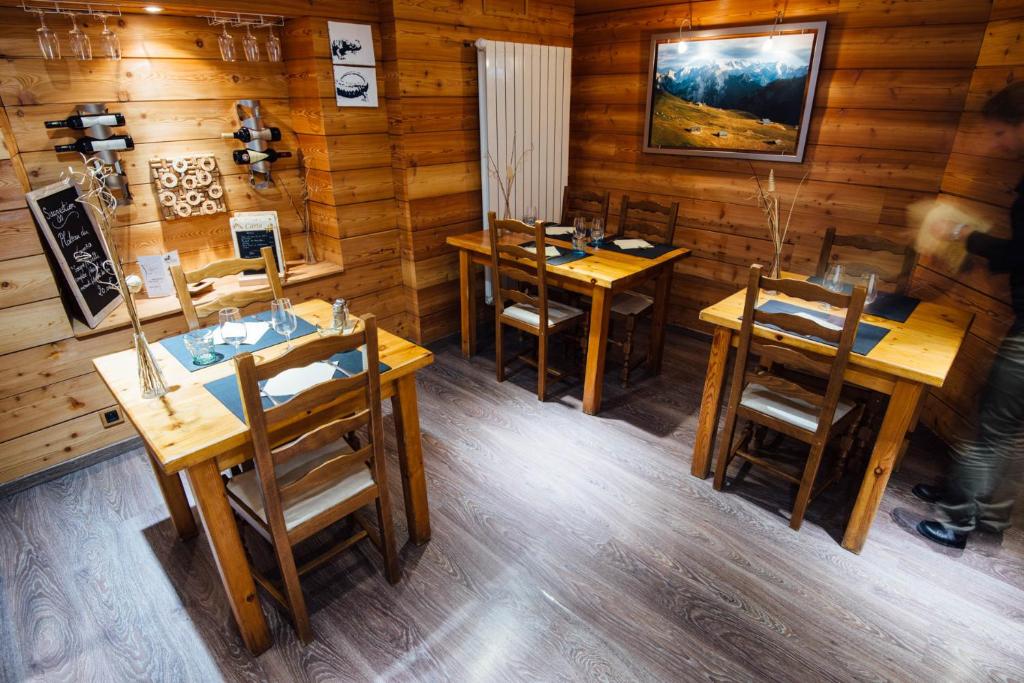 - un restaurant avec des tables et des chaises en bois dans une chambre dans l'établissement Chalet de Lanza, à Abriès