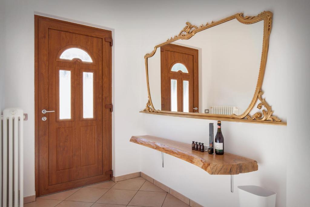 un miroir sur un mur à côté d'une porte dans l'établissement Villa Mimosa-Con piscina e vista lago, à Brenzone