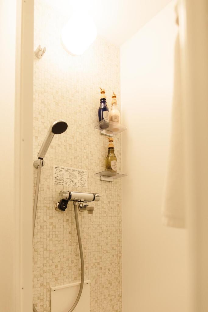 La salle de bains est pourvue d'une douche et d'étagères murales. dans l'établissement Lampstand STAY Asahikawa, à Asahikawa 37 autres photos