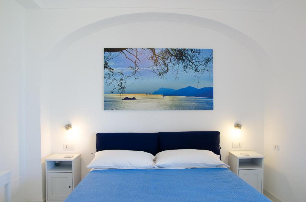 - une chambre avec un lit bleu et 2 tables de nuit dans l'établissement Villa Idris, à Praiano
