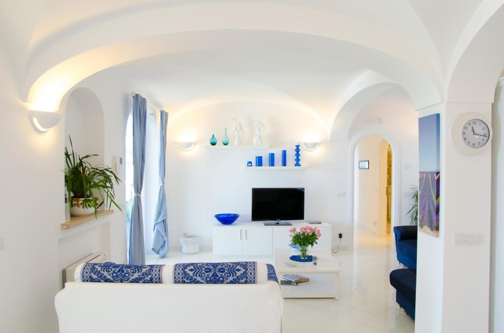 - un salon avec des murs blancs et un canapé blanc dans l'établissement Villa Idris, à Praiano