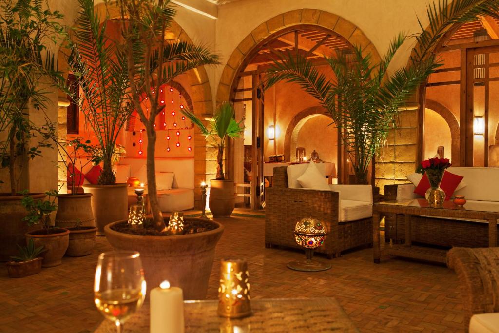 un hall d'hôtel avec des palmiers, des bougies et des verres dans l'établissement Riad Chbanate, à Essaouira