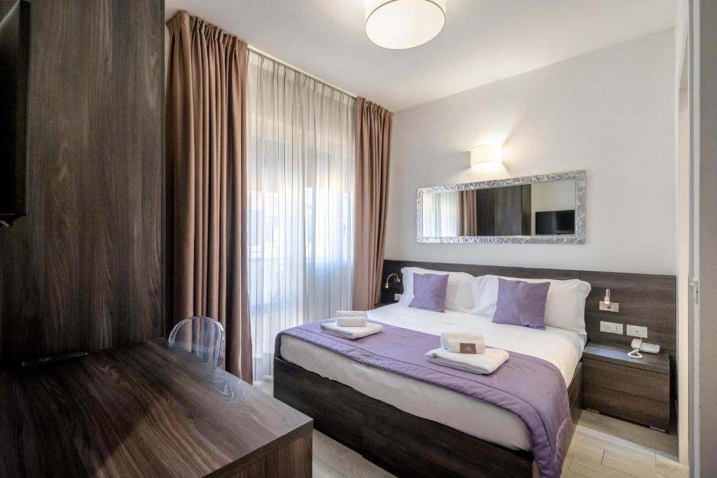 une chambre d'hôtel avec un grand lit avec des draps violets dans l'établissement Hotel Tre Rose, à Caorle 53 autres photos