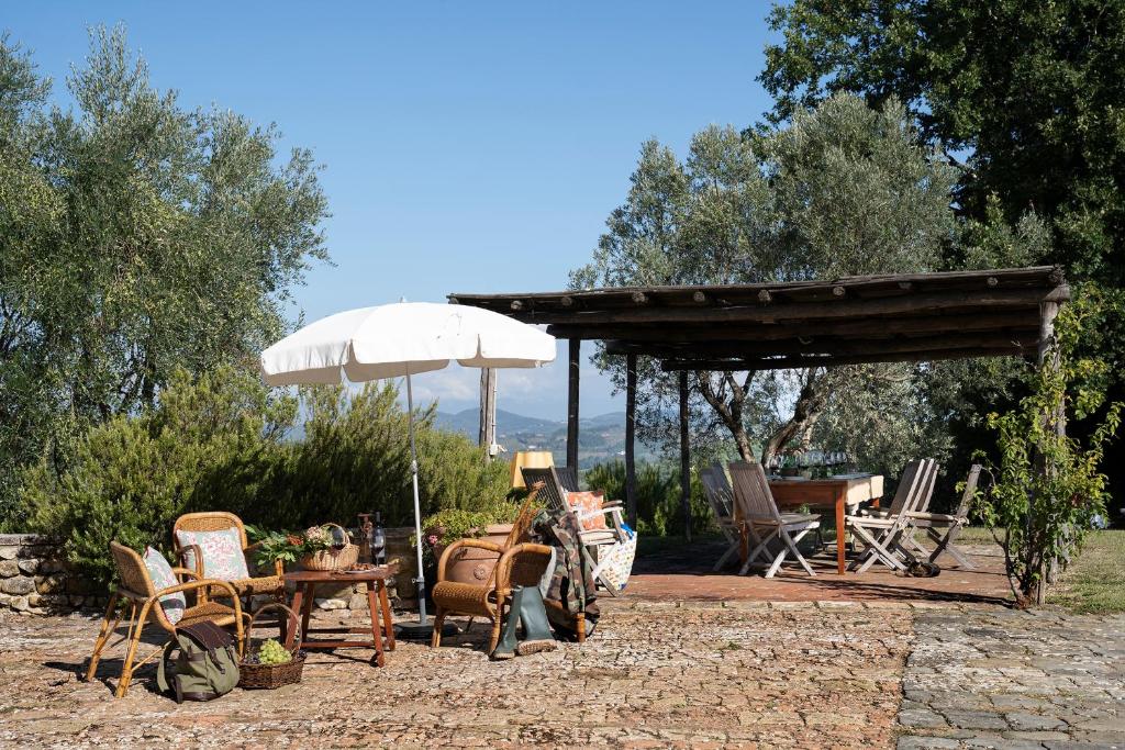 un patio avec une table, un parasol et des chaises dans l'établissement Archipettoli, à San Casciano in Val di Pesa