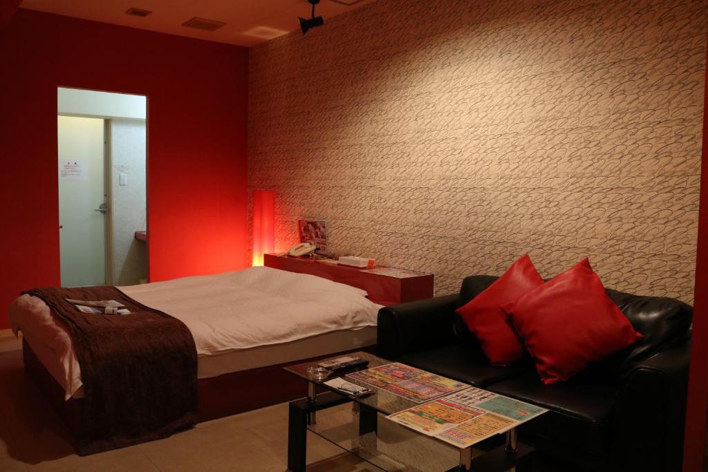 une chambre avec un lit, un canapé et une table dans l'établissement Hotel Sunshine, à Miyazaki