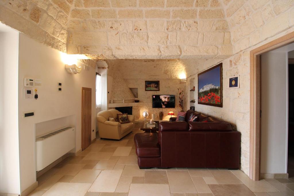 - un salon avec un canapé brun et un mur en pierre dans l'établissement Villa Belvedere, à Ostuni