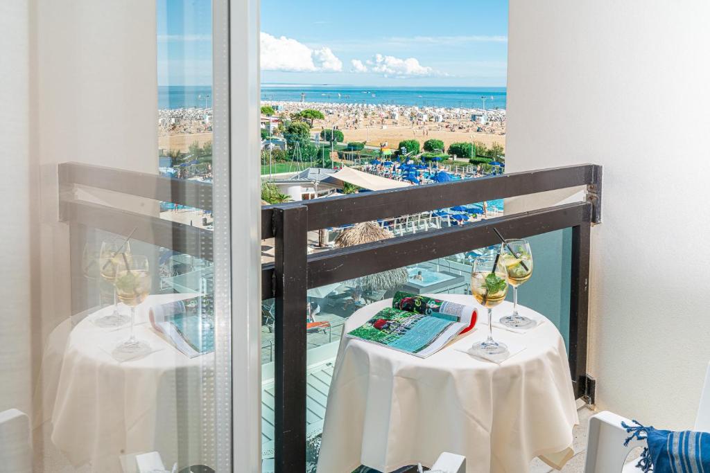 d'un balcon avec deux tables et vue sur la plage. dans l'établissement Hotel Palace, à Bibione