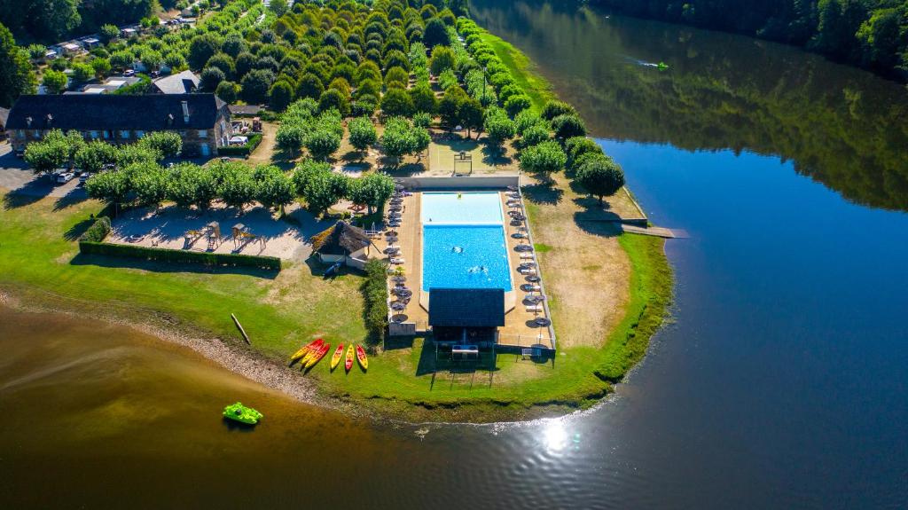 une vue aérienne d'une île avec une piscine dans l'établissement Camping Le château du gibanel, à Saint-Martial-Entraygues