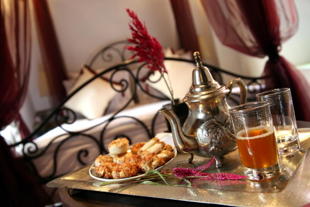 - une table avec une assiette de nourriture et une boisson sur un lit dans l'établissement Riad Terra Bahia, à Marrakech