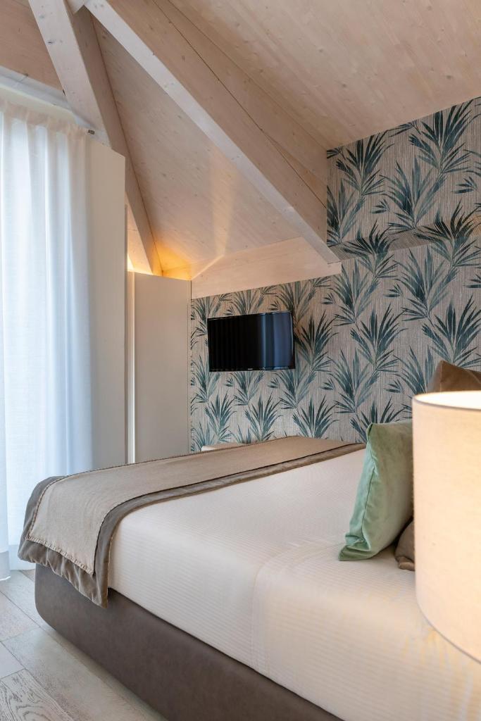 une chambre avec un lit avec une télévision au mur dans l'établissement Residence Lungomare - Charming apartments, à Riccione