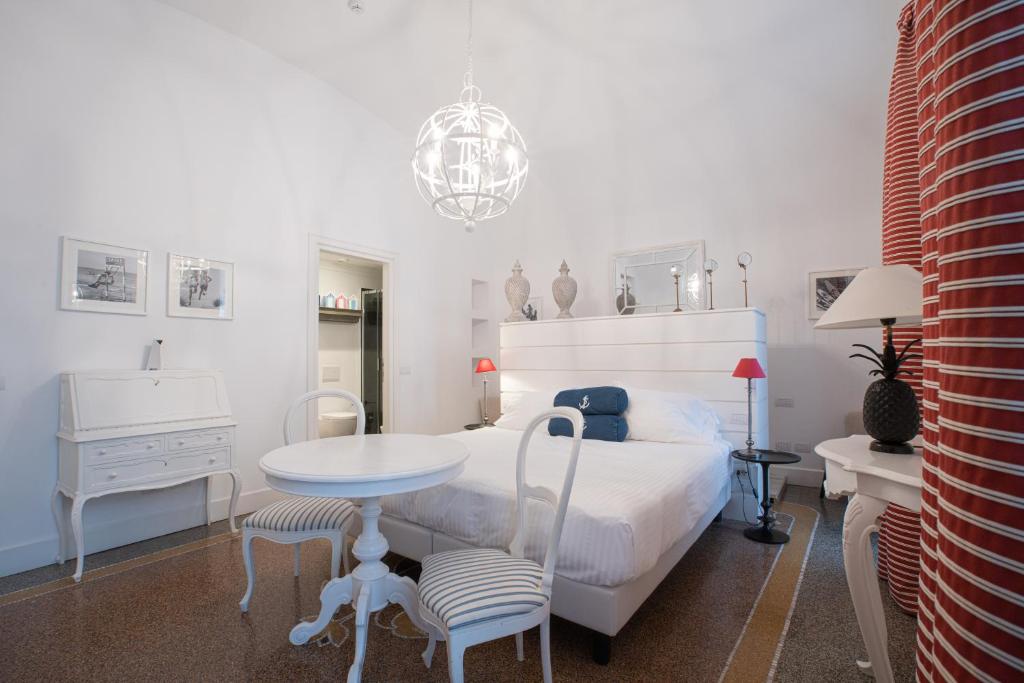 une chambre blanche avec un lit, une table et des chaises dans l'établissement Hotel Marina Charming Rooms, à Finale Ligure