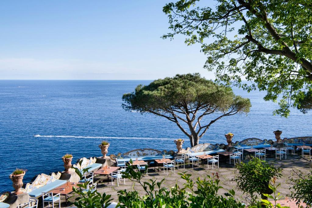 - un groupe de tables et de chaises au bord de l'océan dans l'établissement Il San Pietro di Positano, à Positano