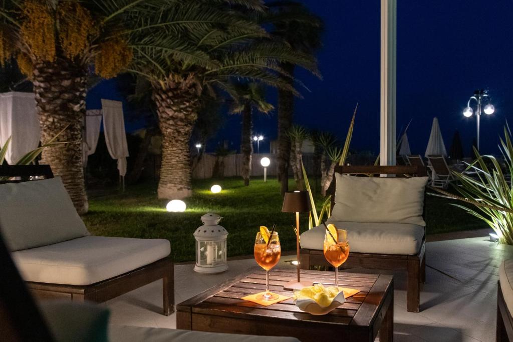 - une terrasse avec 2 chaises et une table avec des verres à vin dans l'établissement Hotel Conchiglia, à Lido di Jesolo