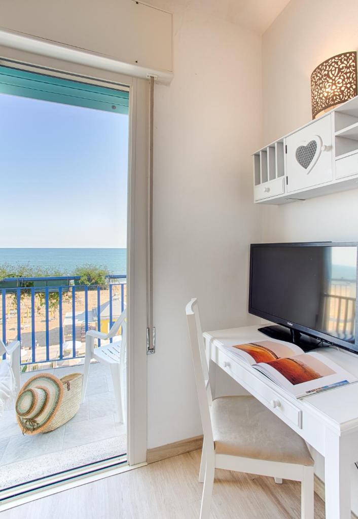 une chambre avec un bureau et une vue sur l'océan dans l'établissement Hotel Conchiglia, à Lido di Jesolo