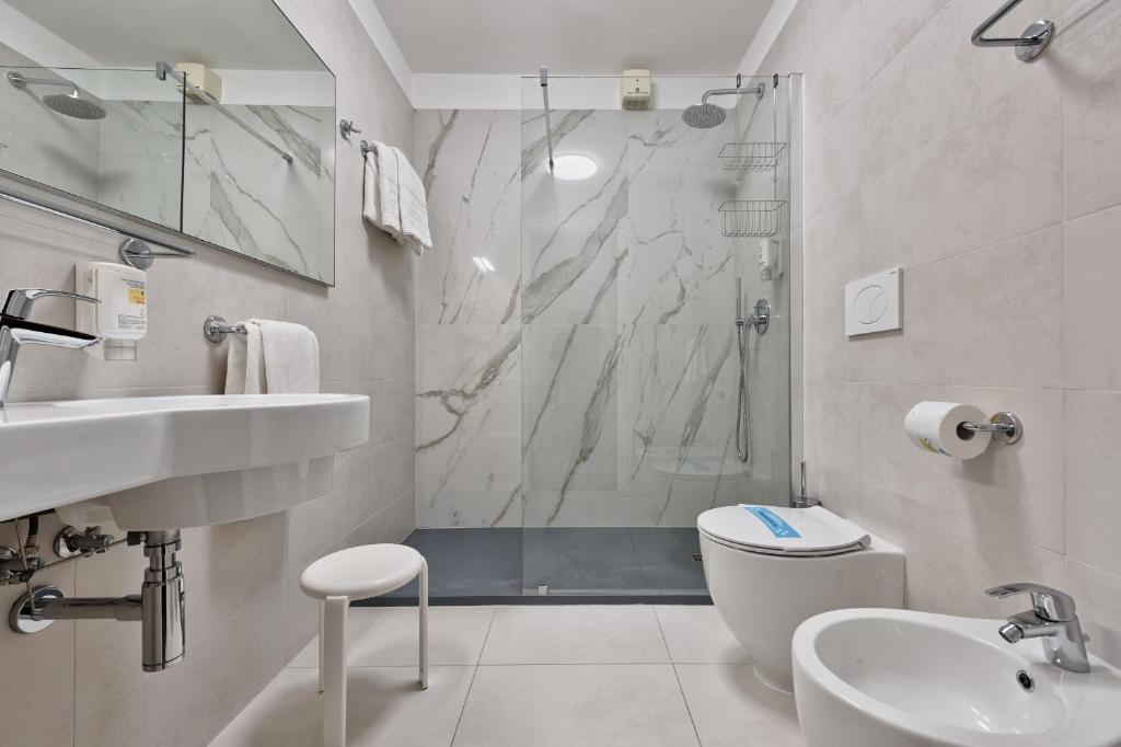 une salle de bain avec une douche, des toilettes et un lavabo dans l'établissement Hotel Croce Di Malta, à Lignano Sabbiadoro