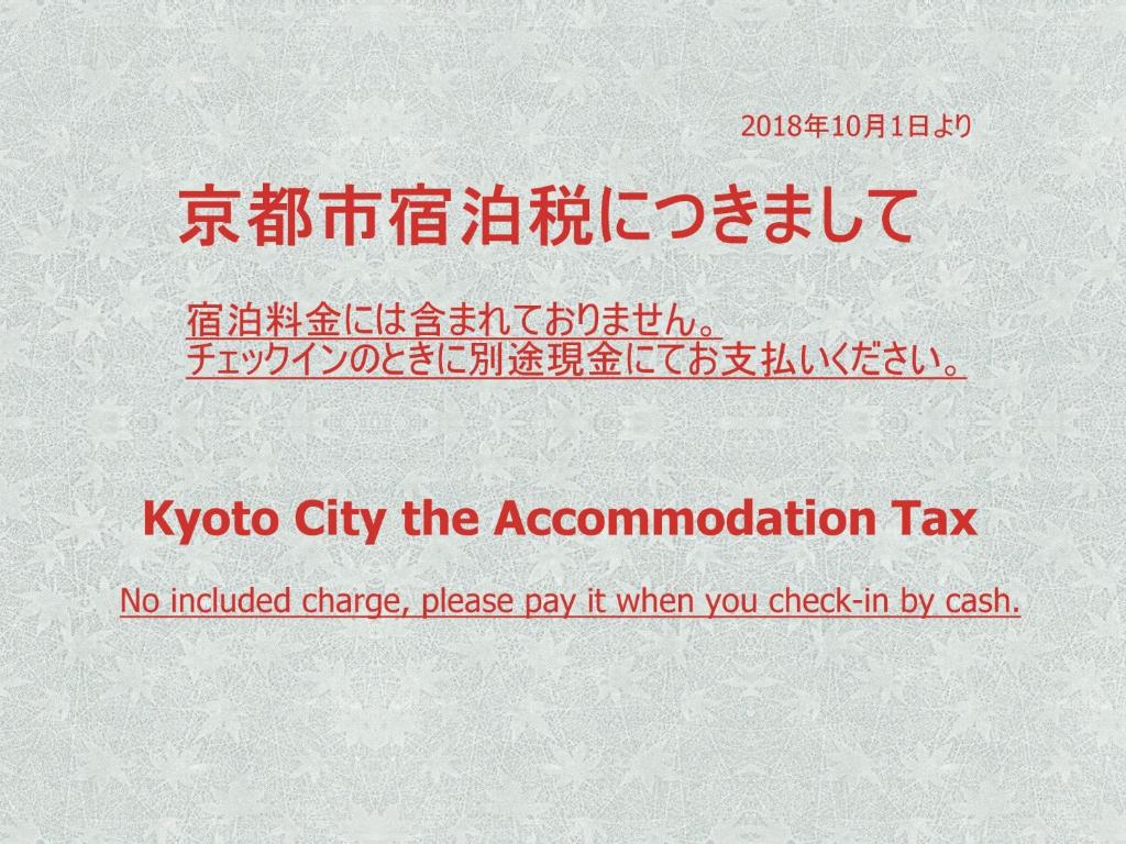 Un panneau indiquant la ville de koko la taxe d'hébergement dans l'établissement Ryokan Kyoraku, à Kyoto