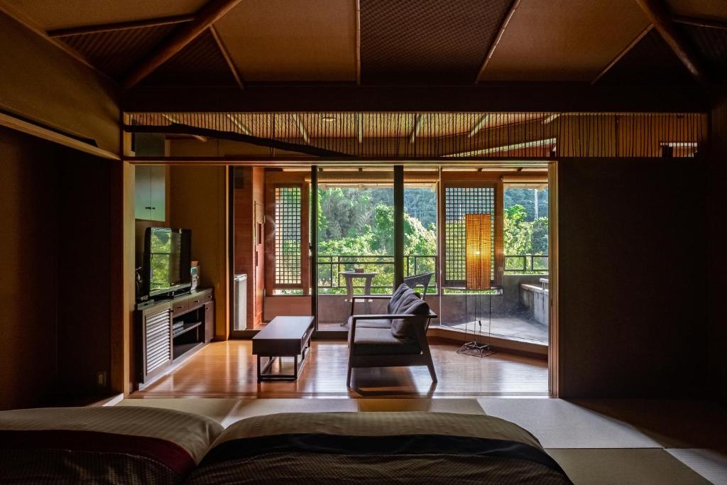 une chambre avec un lit et un salon dans l'établissement Hakuunsou, à Yugawara