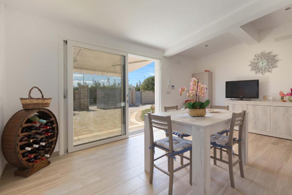 une salle à manger avec une table et une cave à vin dans l'établissement Villa Il Fenicottero Salentino by BarbarHouse, à San Pietro in Bevagna