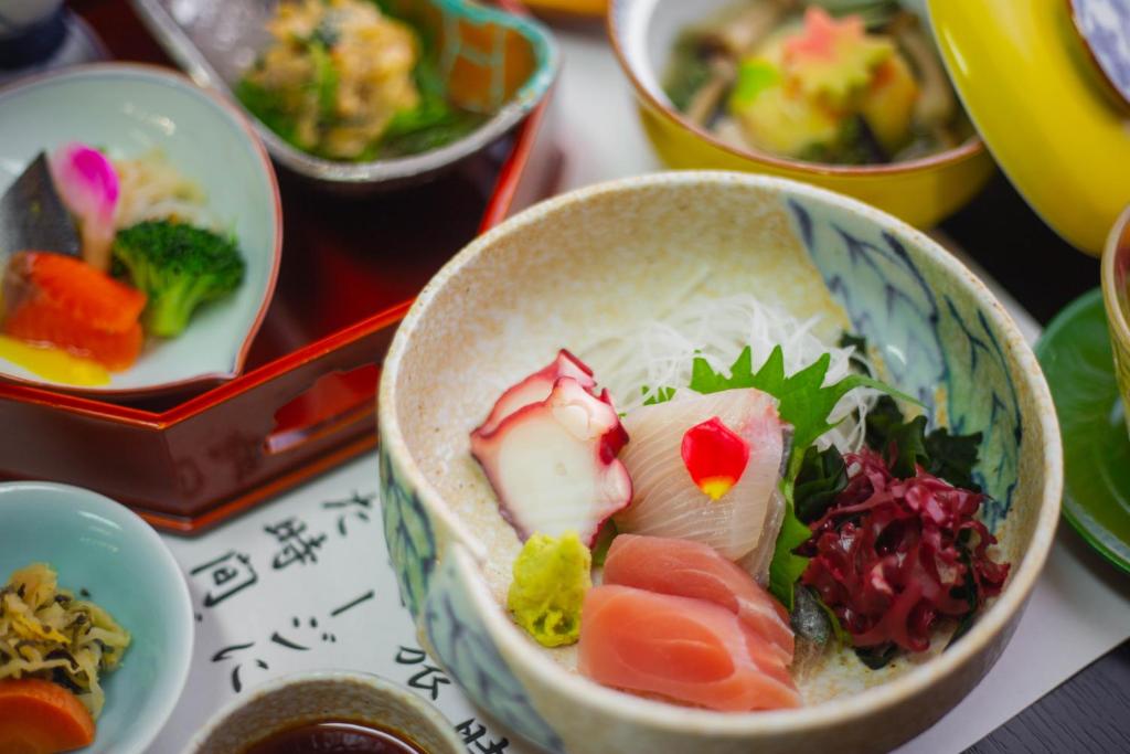 un bol rempli de différents types de nourriture sur une table dans l'établissement Yuzennoyado Toukai, à Ureshino