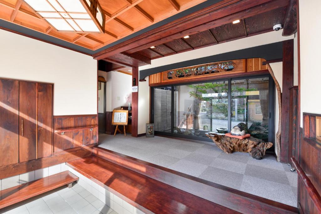 - un hall ouvert avec une personne assise sur un canapé dans l'établissement Kadokyu Ryokan, à Takaoka