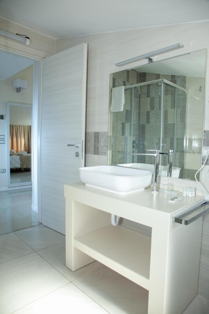 une salle de bain blanche avec un lavabo et un miroir dans l'établissement Hotel Dolce Stella, à Torre Melissa 39 autres photos