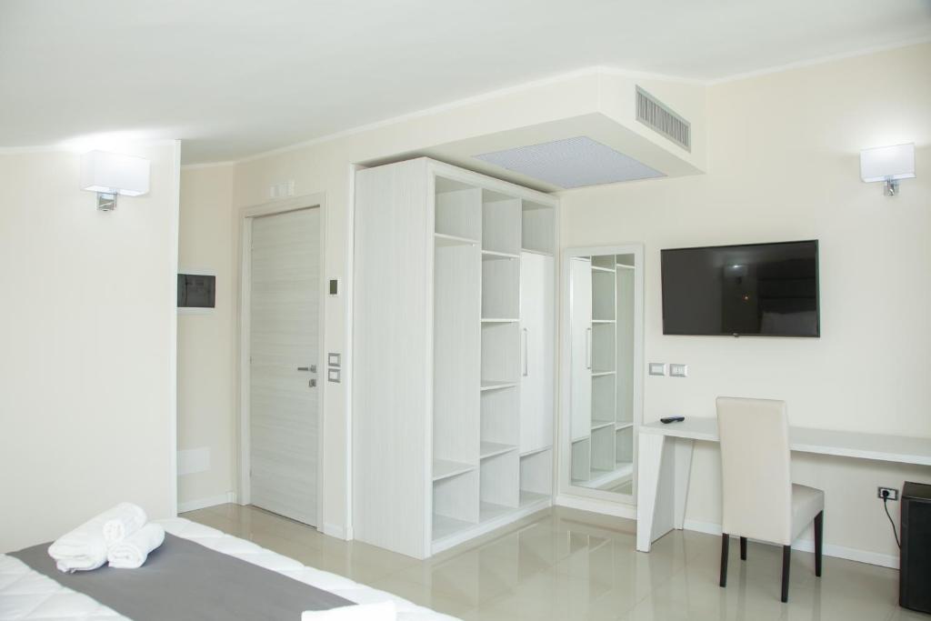 Cette chambre blanche dispose d'un bureau et d'une télévision. dans l'établissement Hotel Dolce Stella, à Torre Melissa