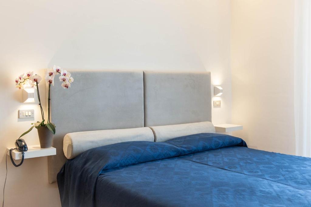 une chambre avec un lit avec une couette bleue dans l'établissement Kiss Beachfront Hotel & Restaurant, à Cervia 147 autres photos