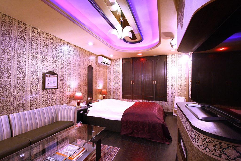 une chambre d'hôtel avec un lit et un canapé dans l'établissement Hotel Ohirune Racco Sakai (Adult Only ), à Sakai