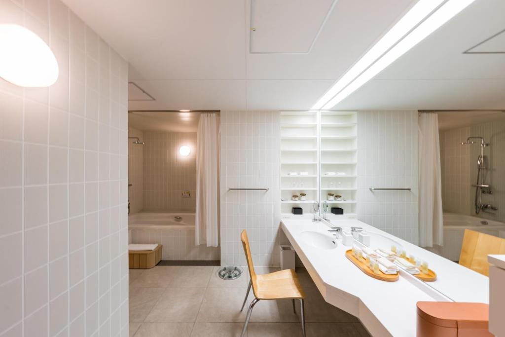 La salle de bains blanche est pourvue d'un lavabo et d'une baignoire. dans l'établissement SETOUCHI RETREAT by Onko Chishin, à Matsuyama