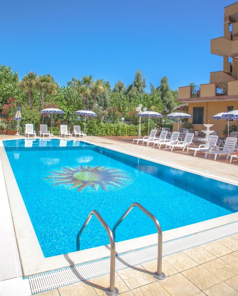 une piscine dans un hôtel avec des chaises et des parasols dans l'établissement Hotel Costazzurra, à Grottammare