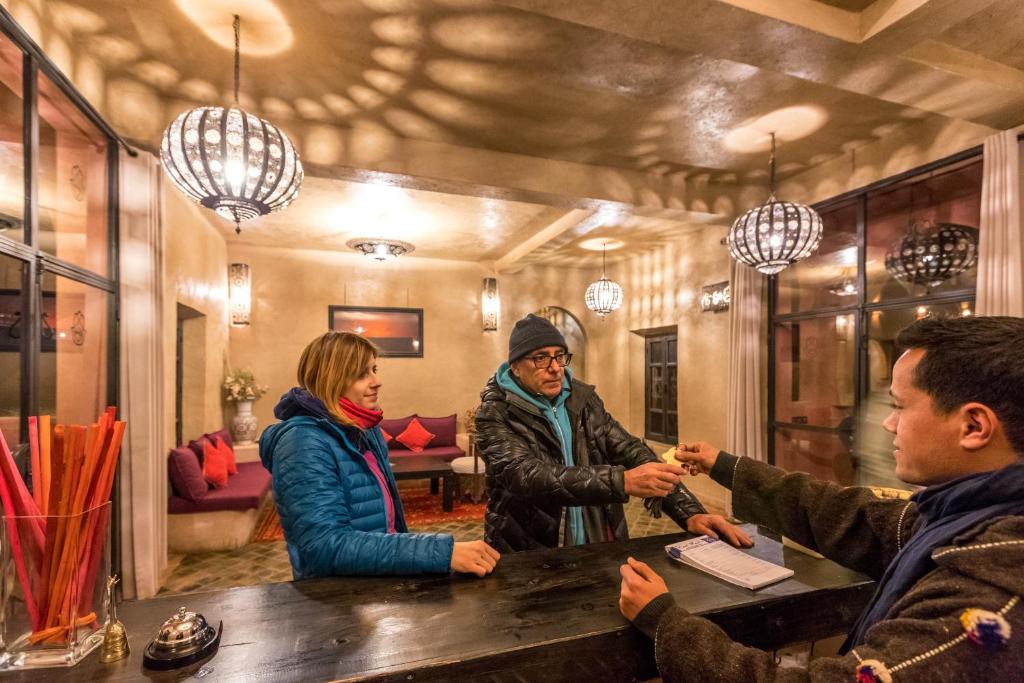 Un groupe de personnes autour d'une table dans un bar dans l'établissement Riad Madu, à Merzouga 37 autres photos