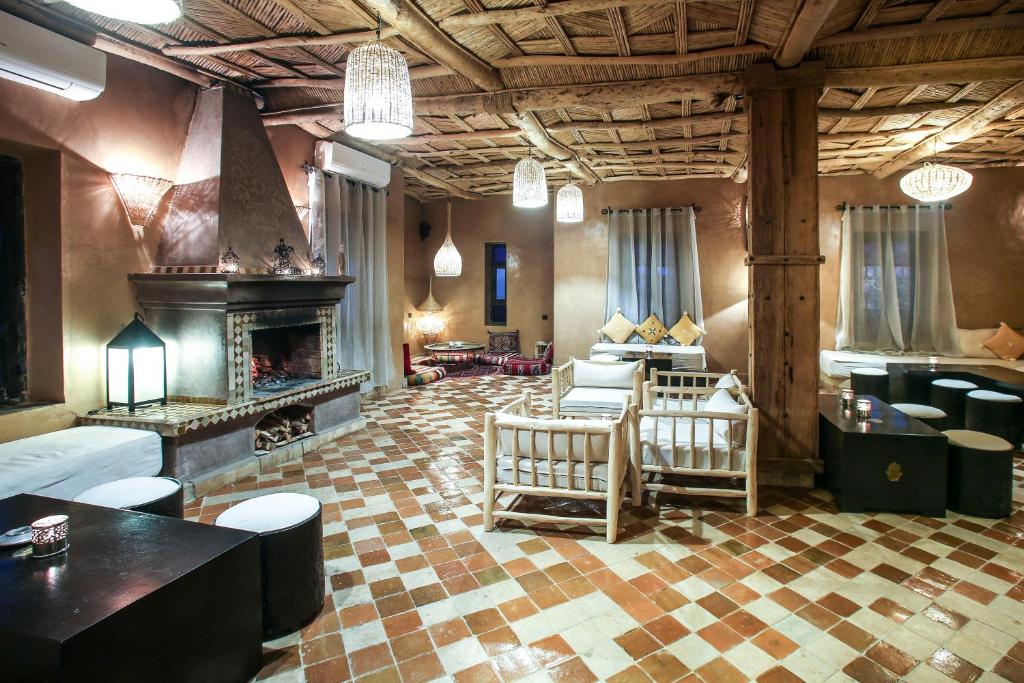 un grand salon avec une cheminée et un canapé dans l'établissement Riad Madu, à Merzouga