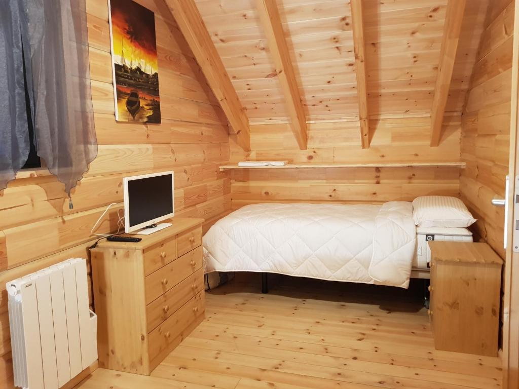 - une petite chambre avec un lit et un ordinateur sur un bureau dans l'établissement Refuges des Hauts, à Bussang