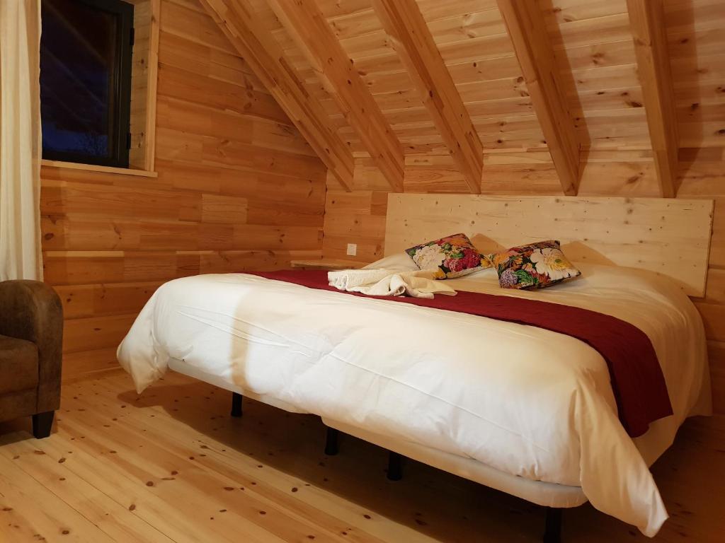 une chambre avec un lit dans une cabane en rondins dans l'établissement Refuges des Hauts, à Bussang
