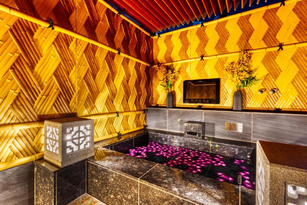 Cette chambre dispose d'une télévision et d'une baignoire ornée de fleurs violettes. dans l'établissement HOTEL Lotus Shibuya (Adult Only), à Tokyo