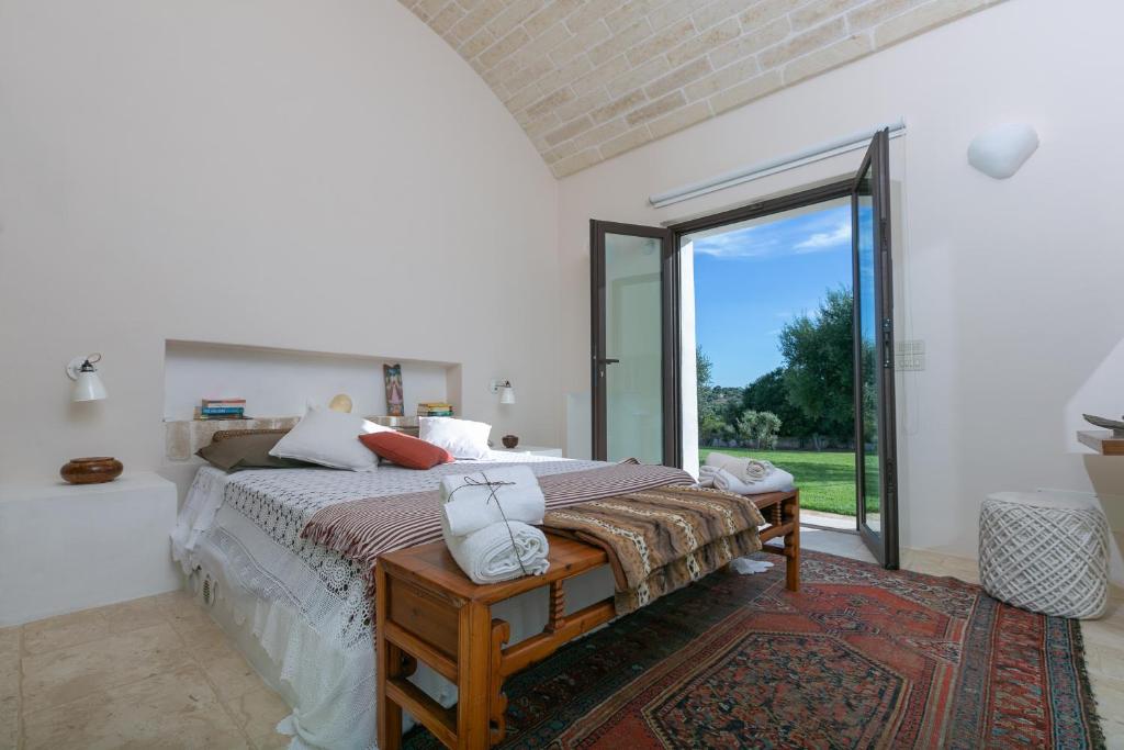 une chambre avec un lit et une grande fenêtre dans l'établissement Villa Moresca dei Trulli Fernando, à Ostuni