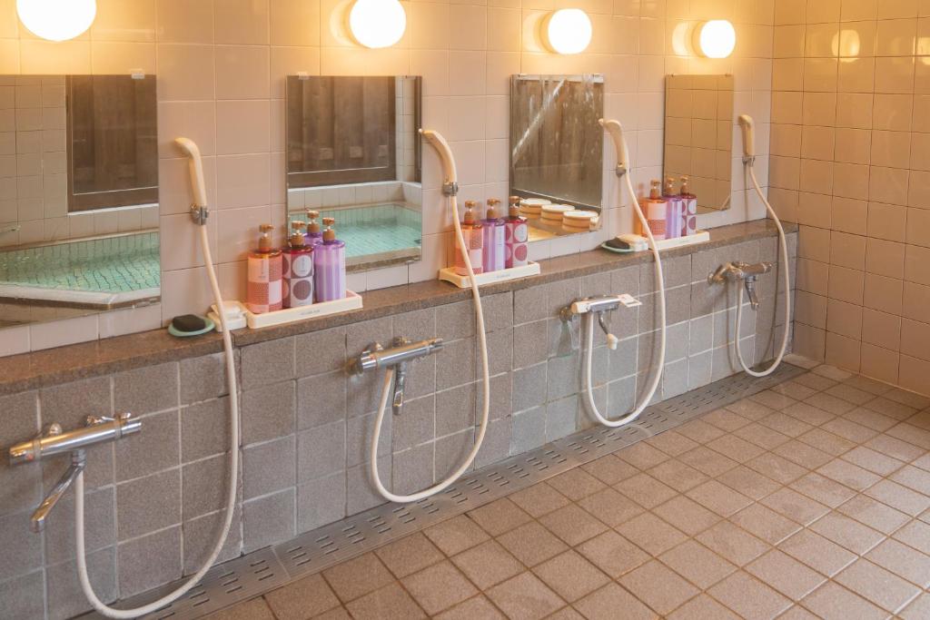 La salle de bains est pourvue de 2 douches et de 2 miroirs. dans l'établissement Bunanoyado Koase, à Aga