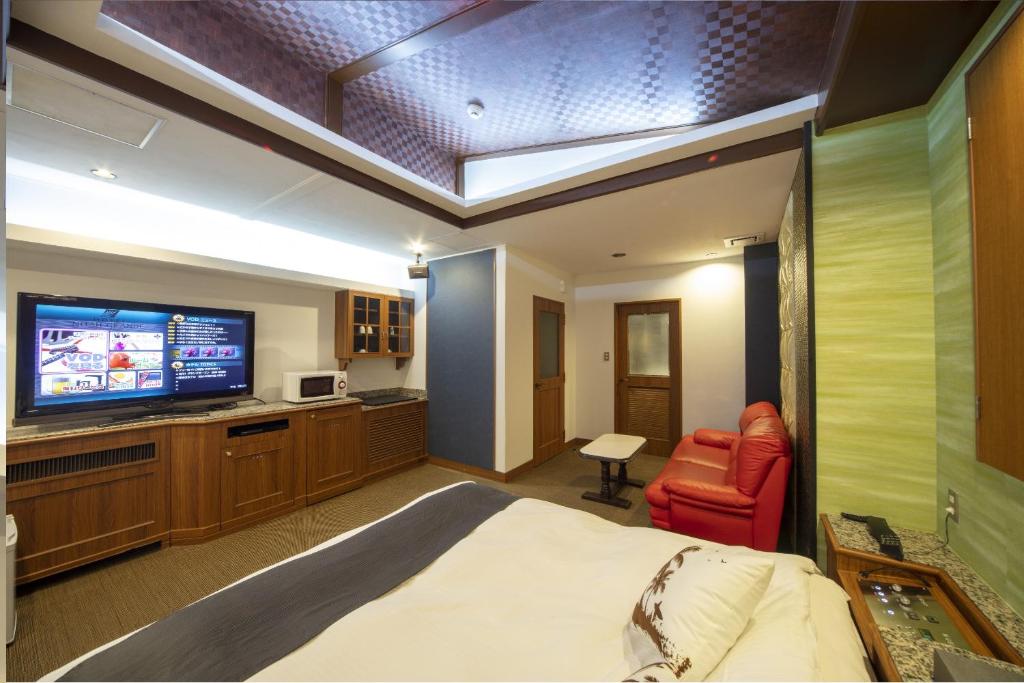 une chambre avec un lit, une télévision et un canapé dans l'établissement noah grande, à Osaka