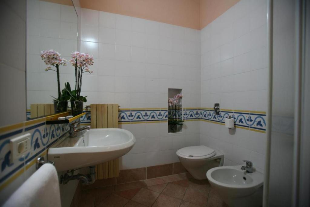 une salle de bain avec un lavabo et des toilettes dans l'établissement Villaggio Colombare, à Sirmione