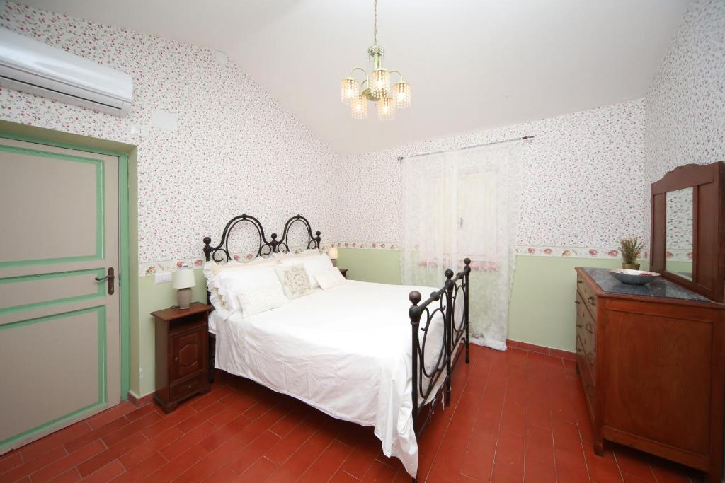 une chambre avec un lit et un lustre dans l'établissement sacrobosco Country House, à Porchiano