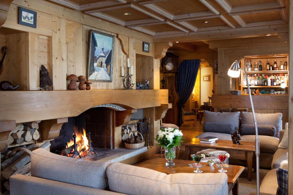 un salon avec une cheminée et un canapé dans l'établissement Hôtel La Grange d'Arly, à Megève