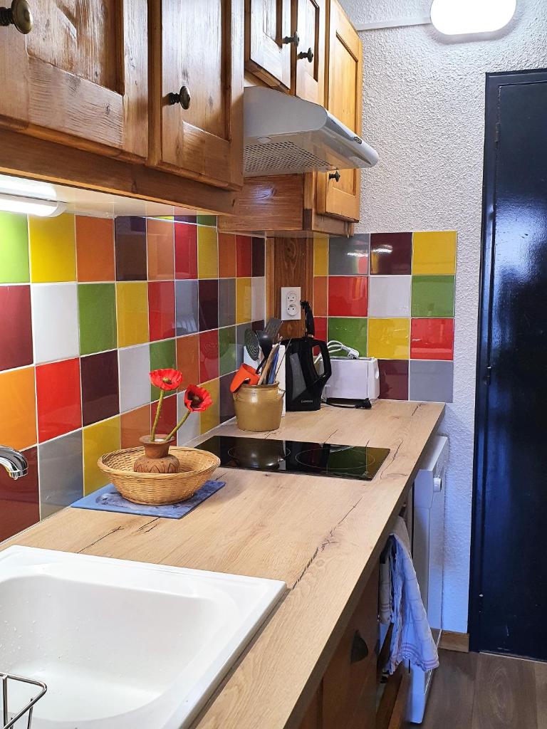 - une cuisine avec un comptoir, un évier et du carrelage coloré dans l'établissement les 3 marmottes - Les Arolles, à Bourg-Saint-Maurice 3 autres photos
