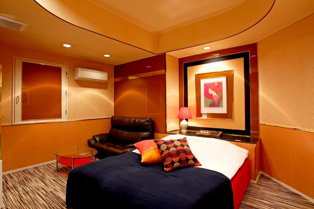 une chambre avec un lit et une chaise dans l'établissement Hotel Savoy - Adult Only, à Tokyo