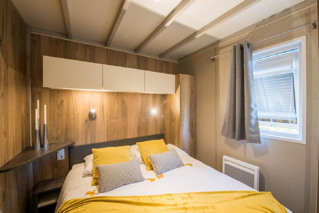 une chambre avec un lit avec des oreillers jaunes et une fenêtre dans l'établissement Domaine de la Forge, à La Teste-de-Buch 37 autres photos