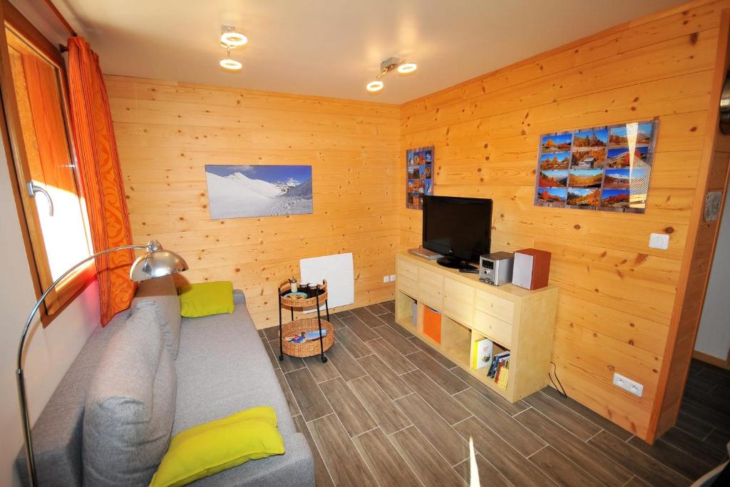un salon avec un canapé et une télévision dans l'établissement Le Balcon des Charmottes, à Névache