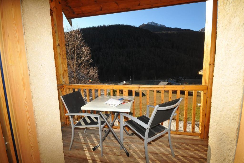 une table et des chaises sur un balcon avec vue dans l'établissement Le Balcon des Charmottes, à Névache